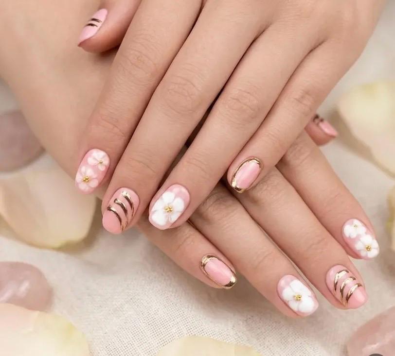Uñas estilo coreano rosa con flores y detalles dorados
